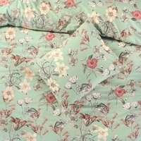 Groene bloemenbeddegoedset met een bijpassend kussen, perfect voor een frisse en natuurlijke slaapkamerlook.