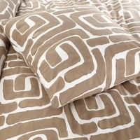 Een bed met een comforter in een wit en bruin patroon, met kussens die een gezellige uitstraling geven.