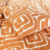 Een oranje en witte bed met een geometrisch patroon, perfect voor een frisse en eigentijdse slaapkamerlook.