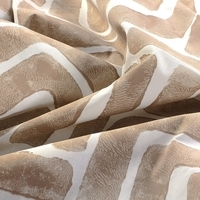 Detailopname van een stof met een uniek patroon, waarbij de kleuren en textuur goed zichtbaar zijn.