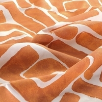 Stof met een opvallende print in oranje en wit, met een speelse en levendige uitstraling.