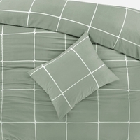 Een bed met een comfortabel groen-wit geruit dekbed, dat een gezellige en rustgevende sfeer uitstraalt.